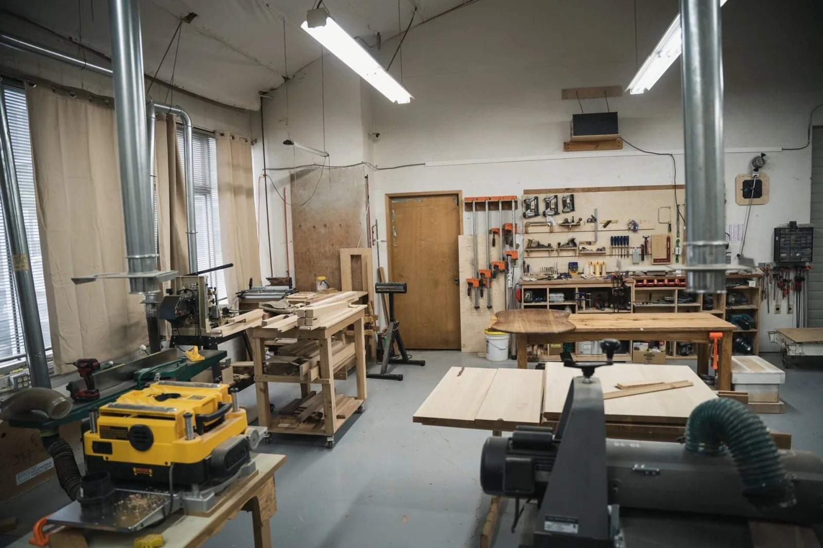 Workbenches, machines and clamps in the PDX Woodworks shop